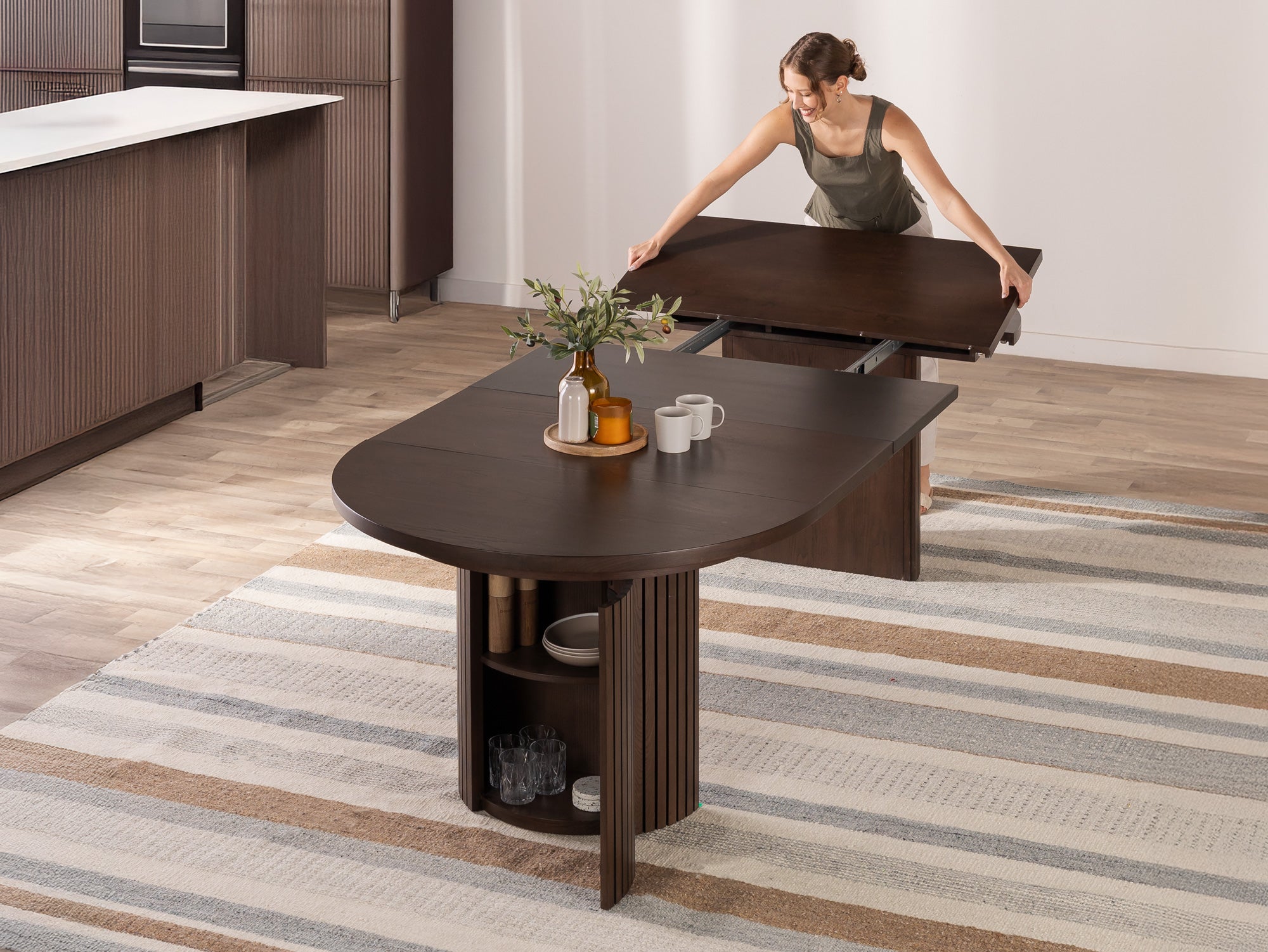 transformer-round-table-dark-walnut-the-table-functionality-lifestyle-model-4x3-1 Transformer Round Table - Image 1